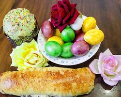 bolos de páscoa doces com ovos coloridos na mesa no quarto foto