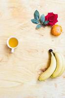 banana fresca e caqui no fundo da parede de tijolos e mesa de madeira, foto