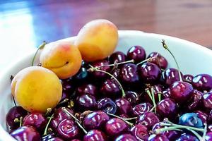 prato com cerejas maduras na mesa foto