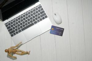 vista superior do laptop com cartão de crédito em uma superfície branca foto