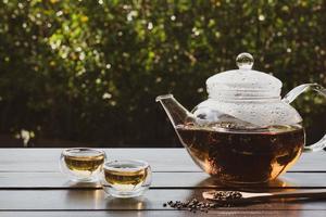 chá chinês quente servindo na mesa no jardim foto