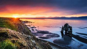 hvitserkur 15 m de altura. é uma rocha espetacular no mar na costa norte da Islândia. esta foto reflete na água após o pôr do sol da meia-noite.