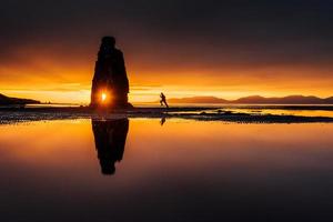 hvitserkur 15 m de altura. é uma rocha espetacular no mar na costa norte da Islândia. esta foto reflete na água após o pôr do sol da meia-noite.