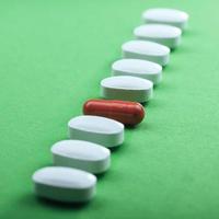 pílulas brancas médicas e cápsulas marrons para o tratamento e cuidados de saúde em um fundo verde foto