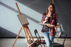 jovem artista pintando um quadro em estúdio foto