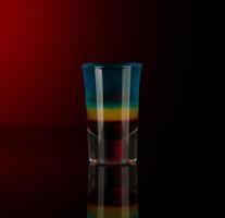 copo com álcool em um fundo escuro foto
