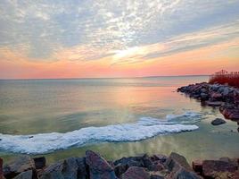 céu pôr do sol sobre o mar à noite com nuvens coloridas foto