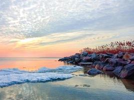 céu pôr do sol sobre o mar à noite com nuvens coloridas foto