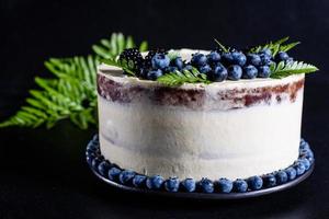 lindo bolo delicioso com mirtilos e creme branco foto