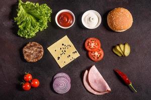 delicioso hambúrguer suculento fresco com costeleta de carne, queijo, tomate e cebola foto