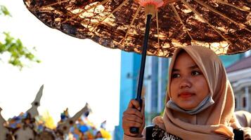 participantes em um traje de batik modificado durante a ação no 113º aniversário do desfile da cidade de pekalongan foto