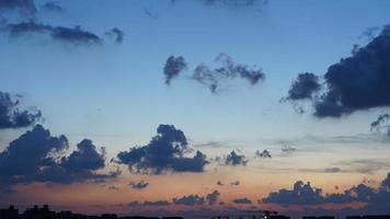 o lindo céu do sol com o céu colorido e nuvens na cidade foto