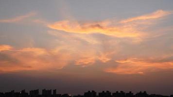 a bela vista do pôr do sol com a silhueta e o céu de nuvens coloridas na cidade foto