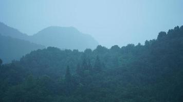 as belas paisagens de montanhas com a floresta verde e a pequena vila como pano de fundo no interior da China foto