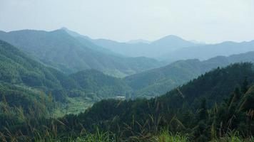 as belas paisagens de montanhas com a floresta verde e a pequena vila como pano de fundo no interior da China foto