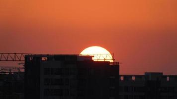 a bela vista do pôr do sol com a silhueta e o céu de nuvens coloridas na cidade foto