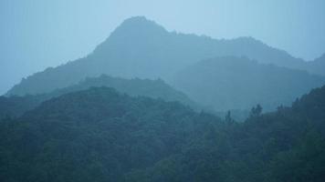 as belas paisagens de montanhas com a floresta verde e a pequena vila como pano de fundo no interior da China foto