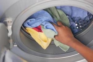 colocar toalhas e panos na máquina de lavar. foto