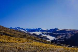 bela paisagem, montanhas cobertas de neve e céu azul foto