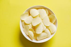 lanche de batatas fritas na tigela e fundo amarelo, batatas fritas crocantes na cozinha foto