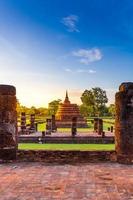 estátua de buda silhueta no templo wat mahathat no parque histórico de sukhothai, província de sukhothai, tailândia. foto