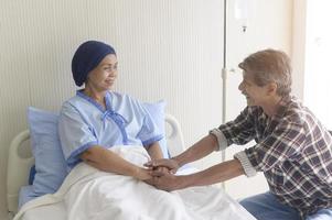 homem sênior visitando mulher paciente com câncer usando lenço na cabeça no hospital, cuidados de saúde e conceito médico foto
