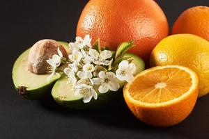 toranja, laranja e abacate, isolados em um fundo preto foto