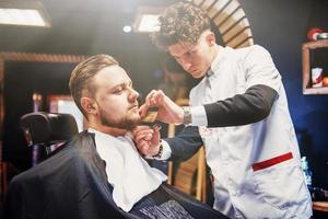 penteado e corte de cabelo masculino em uma barbearia ou salão de cabeleireiro. foto