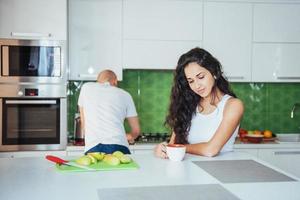 jovem casal feliz tomando café na cozinha foto