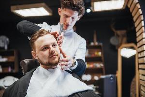 penteado e corte de cabelo masculino em uma barbearia ou salão de cabeleireiro. foto