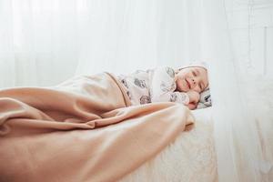 criança menina dorme na cama foto