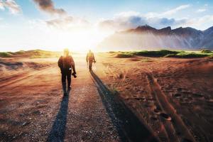 fantástico oeste das montanhas e dunas de areia de lava vulcânica para a praia stokksness. turistas viajando pelo deserto foto