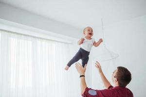 pai jogando mão filha alegre de ar alto. foto