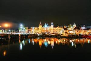 iluminação noturna de edifícios e barcos perto da água no canal. foto