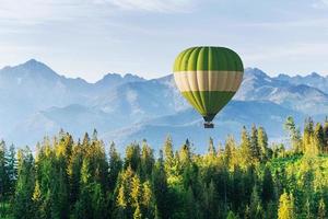 fantásticas montanhas cobertas de neve nas belas nuvens cumulus. um balão ao fundo. Cárpatos. Ucrânia foto