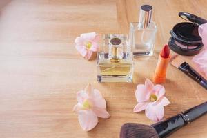 cosméticos de perfume e maquiagem em fundo de madeira foto
