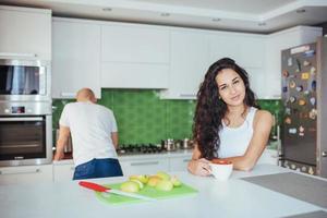 jovem casal feliz tomando café na cozinha foto