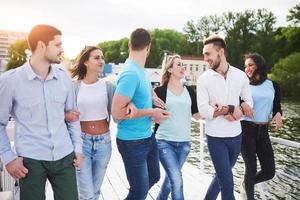 grupo de jovens sorridentes e bem sucedidos de férias na doca foto