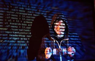 ataque cibernético com hacker encapuzado irreconhecível usando realidade virtual, efeito de falha digital foto