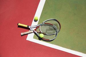 uma raquete de tênis e uma nova bola de tênis em uma quadra de tênis recém-pintada foto