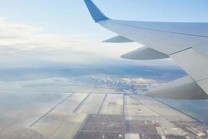 vista para a asa do avião no céu. conceito de viagens e transporte foto