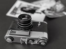 câmera de filme vintage com fotos em preto e branco sobre a mesa. vintage, filme, antigo conceito de tecnologia