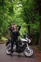 uma garota sexy atraente em uma moto esportiva posando do lado de fora foto