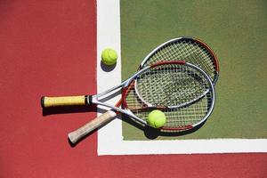 uma raquete de tênis e uma nova bola de tênis em uma quadra de tênis recém-pintada foto