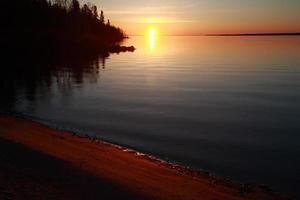 nascer do sol refletido ao longo da margem do lago winnipeg foto