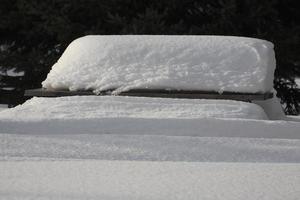 pacotes de neve pesada na mesa de piquenique foto