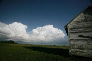 nuvens de tempestade atrás do antigo celeiro de saskatchewan foto