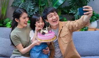 jovem casal asiático comemora o aniversário de sua filha foto