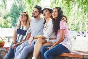 grupo de amigos relaxando e jogando juntos. jovens conversam nas ruas, pesam e jogam juntos foto