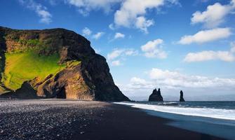 famosas formações rochosas reynisdrangar na praia preta de reynisfjara. costa do oceano atlântico perto de vik, sul da islândia foto